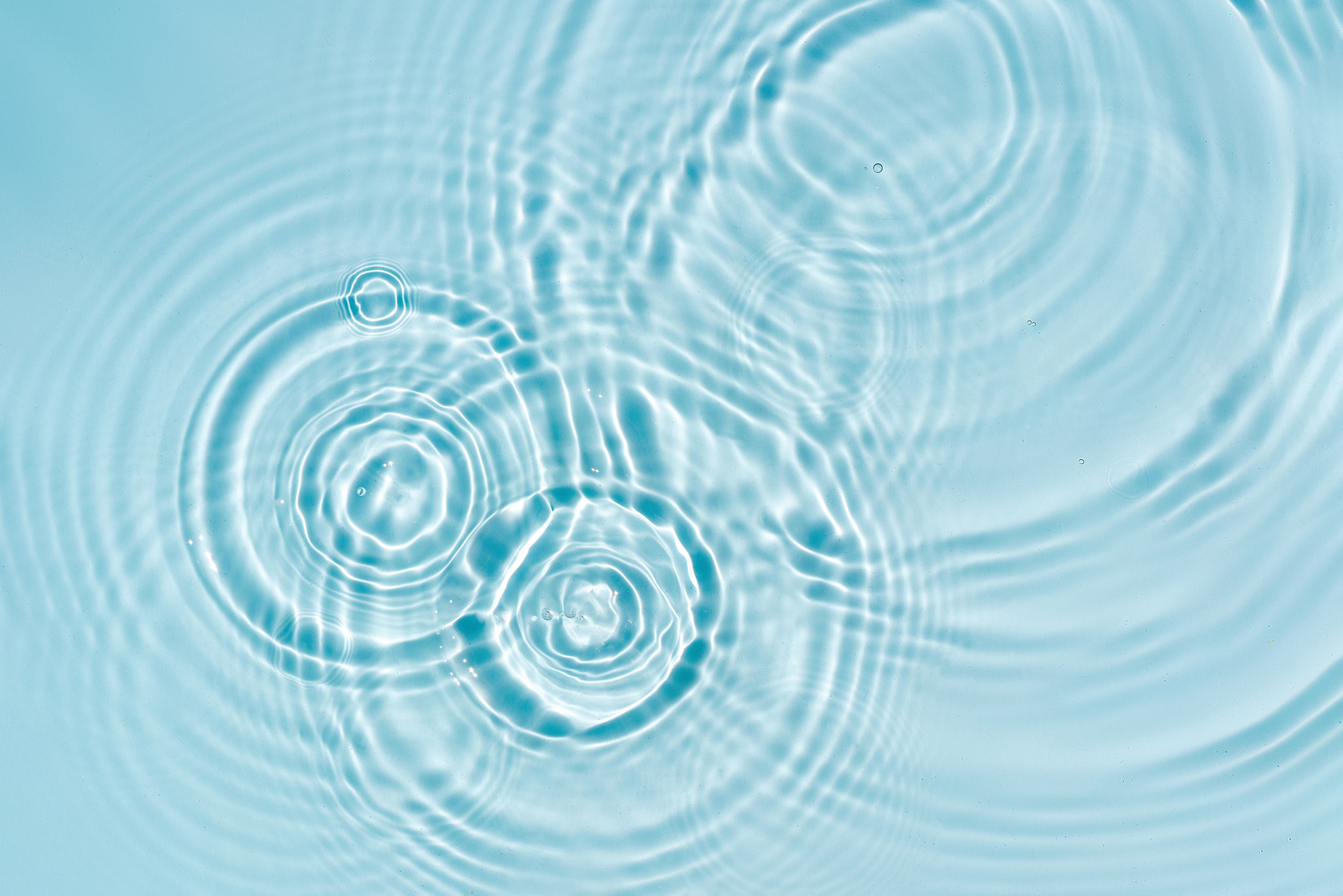 Blue water texture, blue mint water surface with rings and ripples. Spa concept background